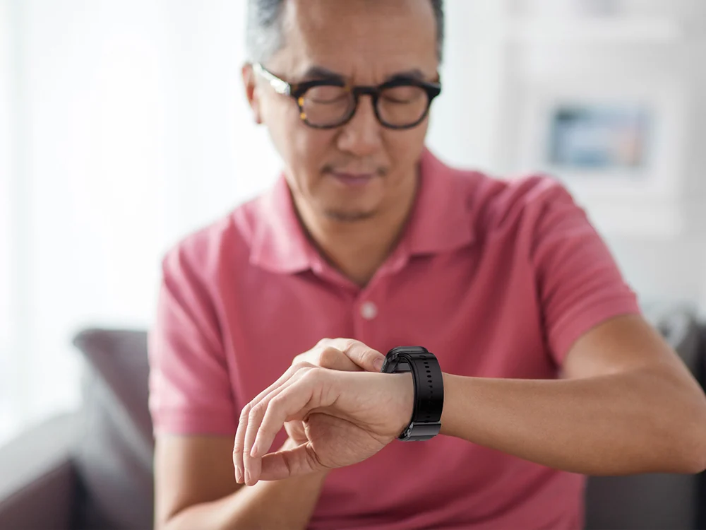 Man checking his health watch during an at-home routine